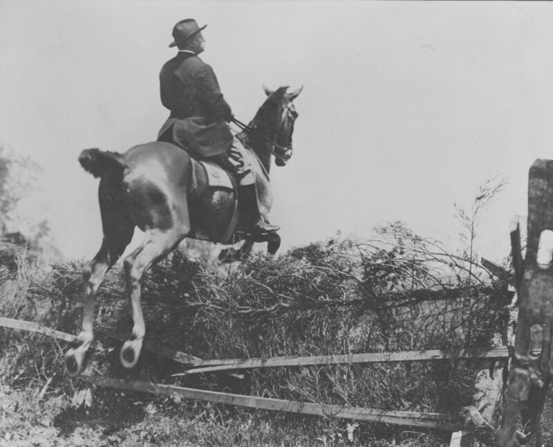 1902, Theodore Roosevelt jumping over a fence on horseback