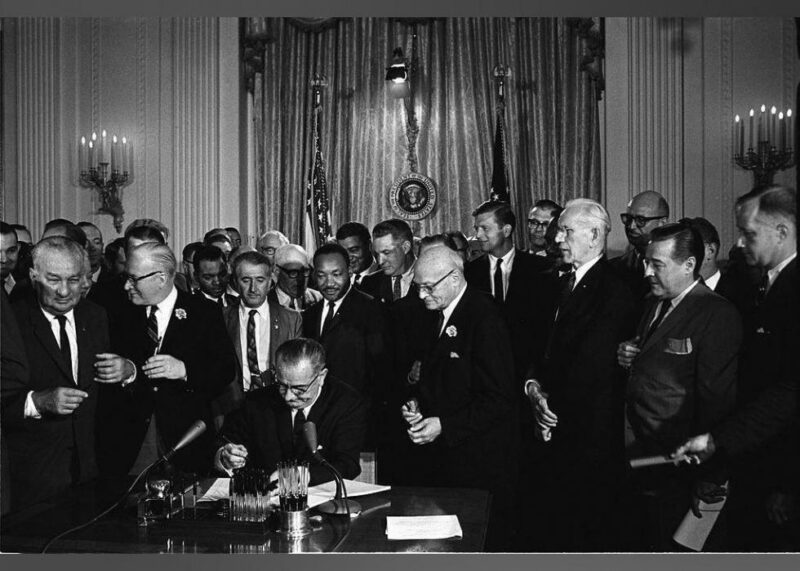 1964, Lyndon B. Johnson signs the Civil Rights Act
